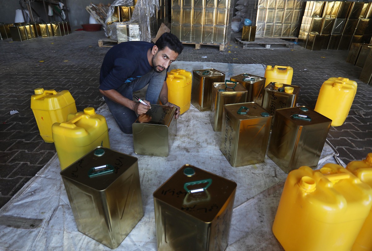 عمال فلسطينيون يجهزون صفائح زيت الزيتون لتصديرها لدول الخليج في مدينة خان يونس جنوب قطاع غزة 9.jpg