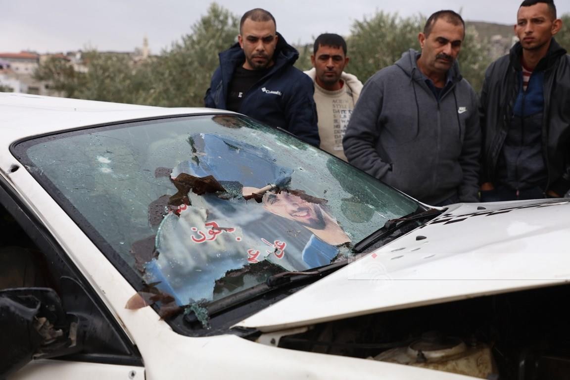 مواطنون يتفقدون المركبة التي اغتال الاحتلال بداخلها الشهيدين امجد خليلية ( 21 عام ) وعز الدين حمامرة ( 22 عام ) بالقرب من بلدة جبع 77.jpg