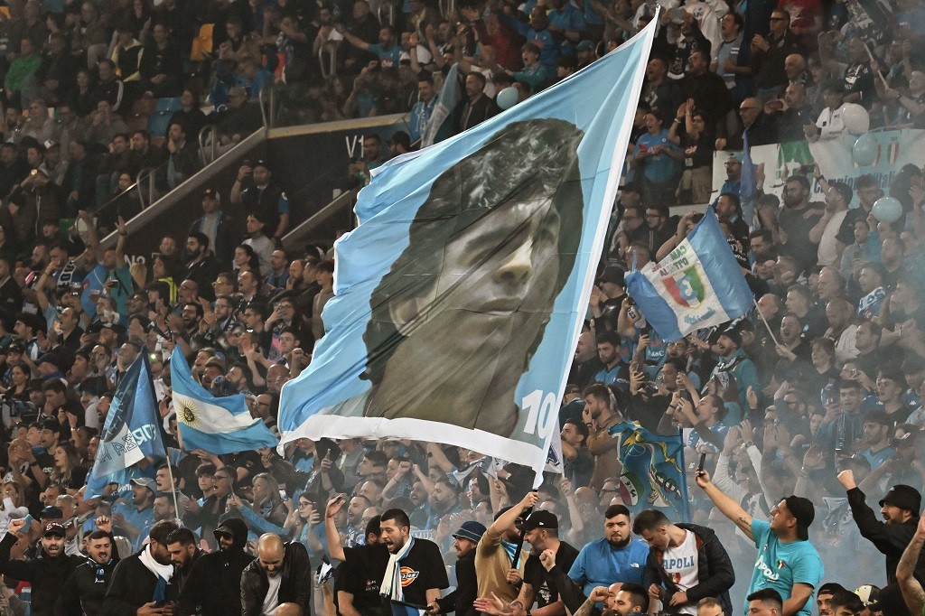 جماهير نابولي ترفع صورة نجمها الأرجنتيني الراحل دييغو مارادونا خلال احتفالها بحسم لقب الدوري الإيطالي للمرة الثالثة في التاريخ (تصوير - أ ف ب).jpg