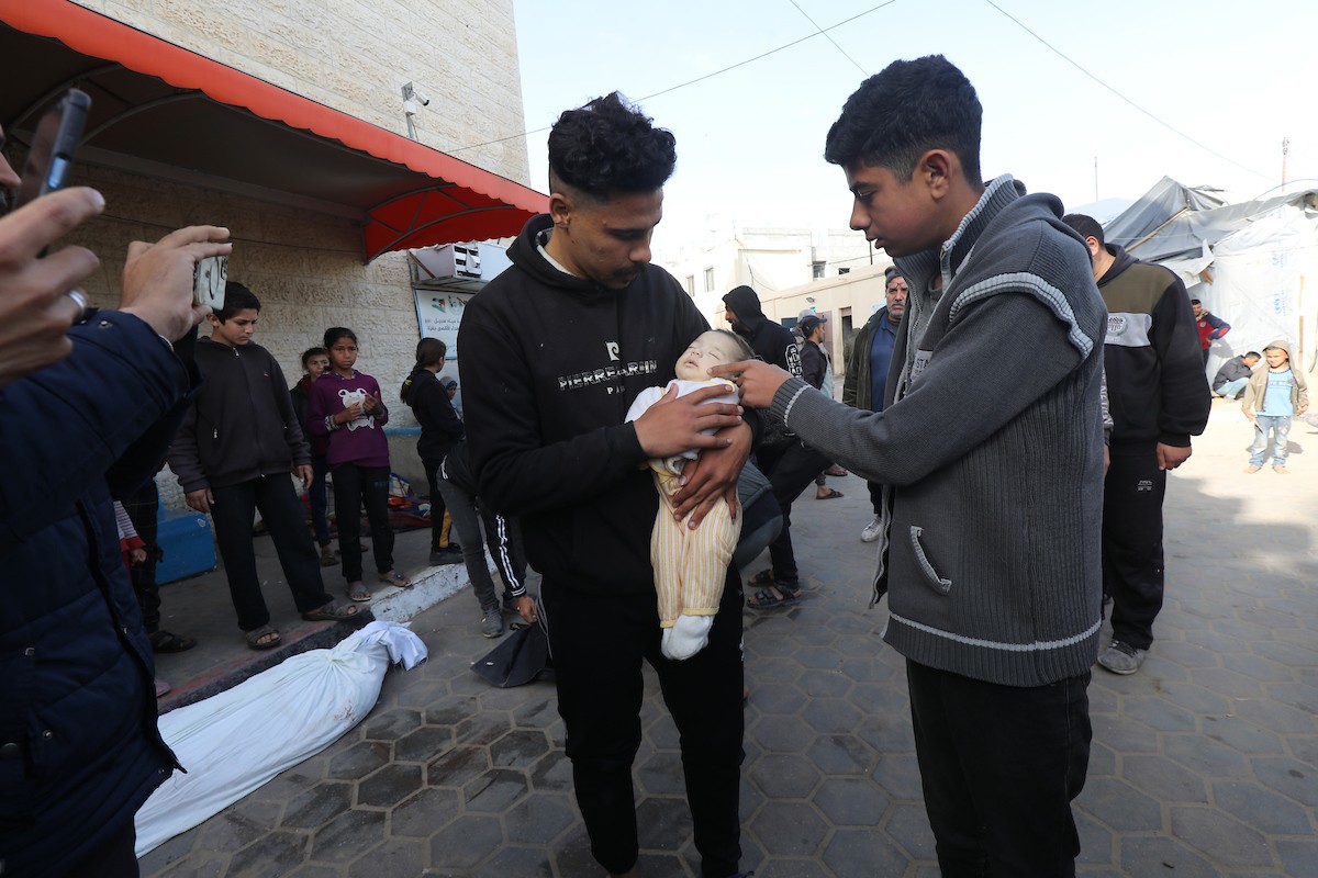 أقارب الفلسطينيين الذين قتلوا في الهجمات الإسرائيلية، يبكون أثناء استلامهم الجثث من مشرحة مستشفى الأقصى لدفنها في دير البلح، غزة، في 17 مارس 2024. تصوير: علي حمد