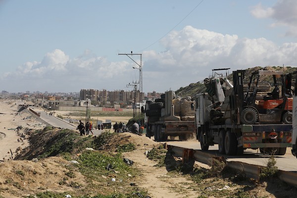 شاحنات تنقل معدات ثقيلة وكتل إسمنتية كبيرة الحجم لاستخدامها في إنشاء رصيف جديد على شاطئ بحر مدينة غزة، بتاريخ 15/3/2024. تصوير : عمر اشتوي