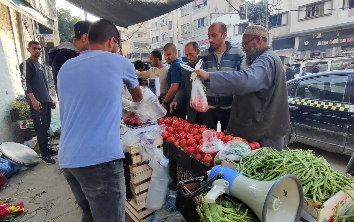 فلسطينيون يتجولون في أحد الأسواق لشراء الخضار والمواد الغذائية في مدينة غزة، 16 أبريل 2024. تصوير: خالد داود