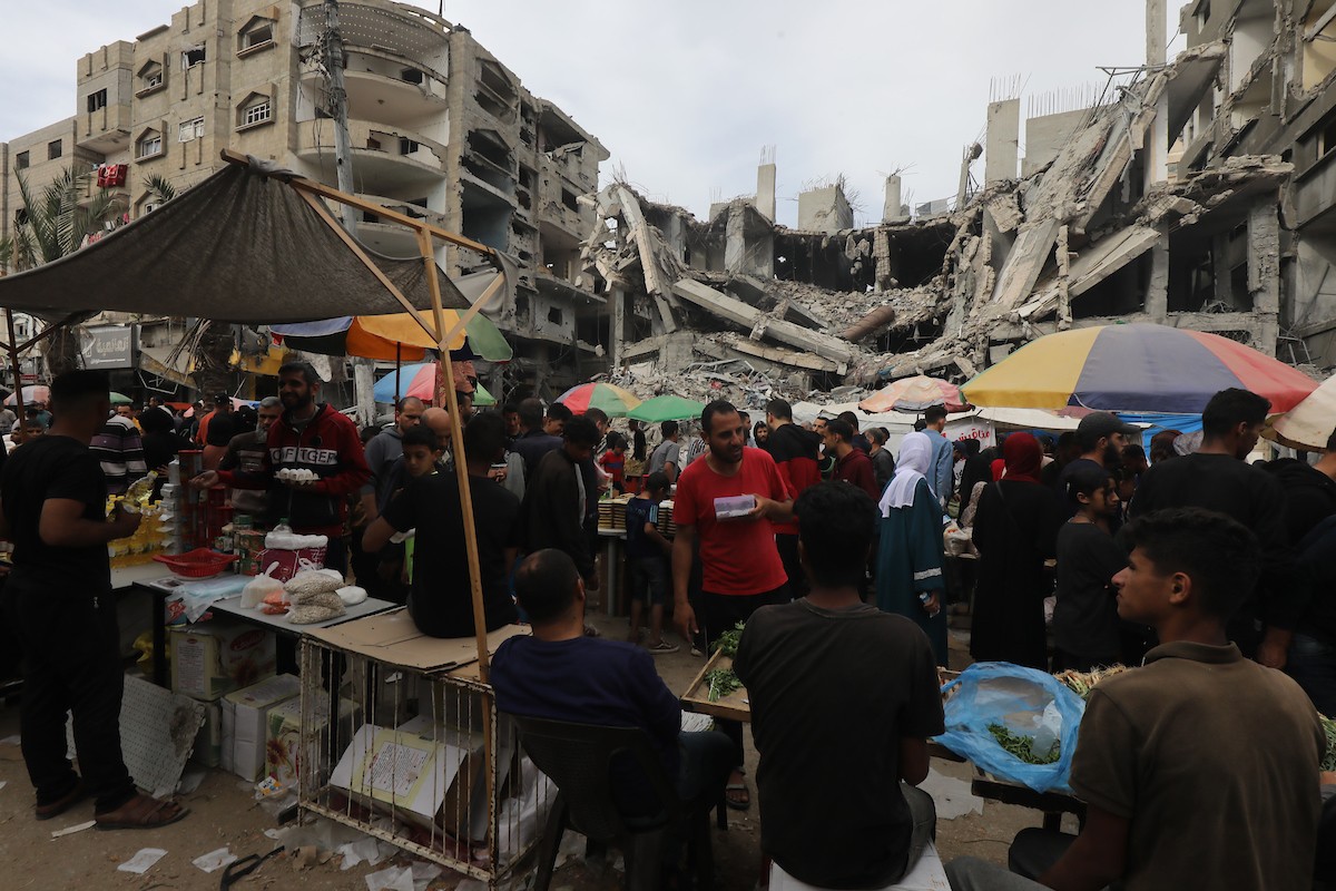 أشخاص يتسوقون من الباعة في سوق مفتوح وسط الدمار في النصيرات وسط قطاع غزة، 05 أبريل 2024. تصوير :نعمان عمر