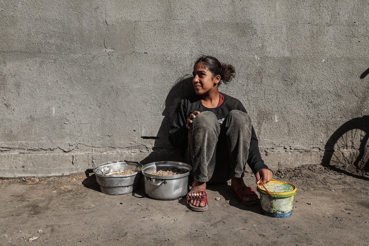 فلسطينيون في مخيم النصيرات وسط قطاع غزة يتلقون وجبات ساخنة من جمعية خيرية للنازحين