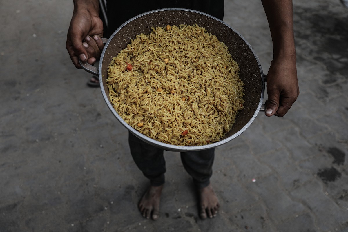 طوابير طويلة للحصول على وجبات ساخنة توزعها جمعيات خيرية في مخيم النصيرات