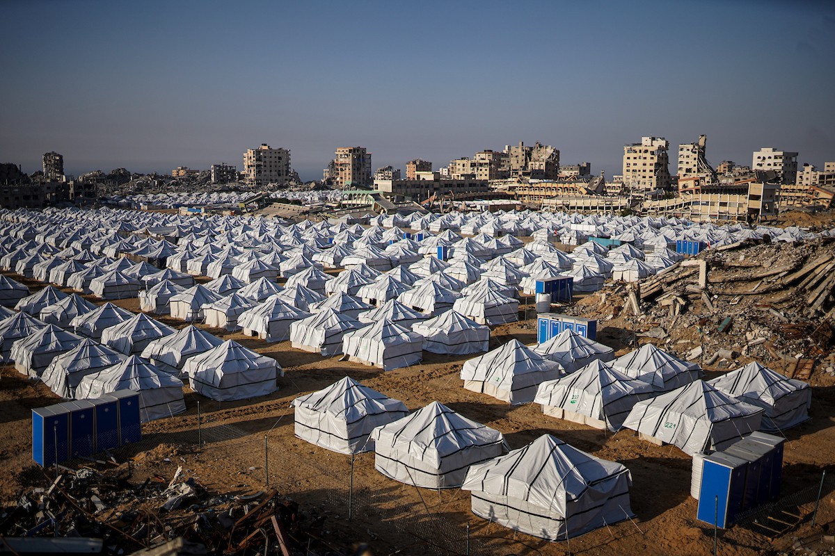 نازحون فلسطينيون يسيرون وسط ملاجئ مؤقتة شمال مدينة غزة