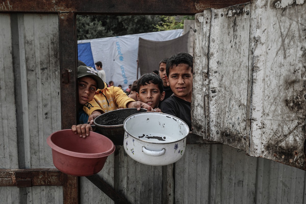 فلسطينيون في مخيم النصيرات وسط قطاع غزة يتلقون وجبات ساخنة من جمعية خيرية للنازحين