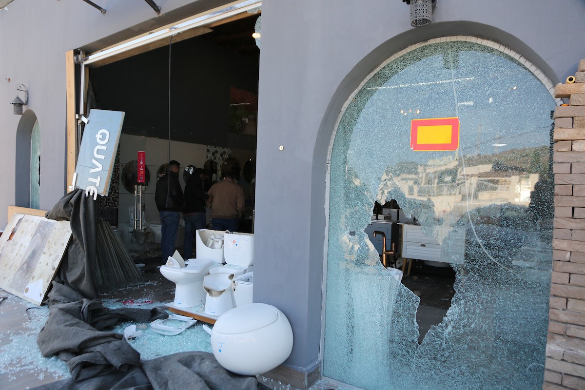 يتفقد الفلسطيني محمد مرقة متجره المتضرر بعد أن هاجمته مجموعة من المستوط (7).JPG