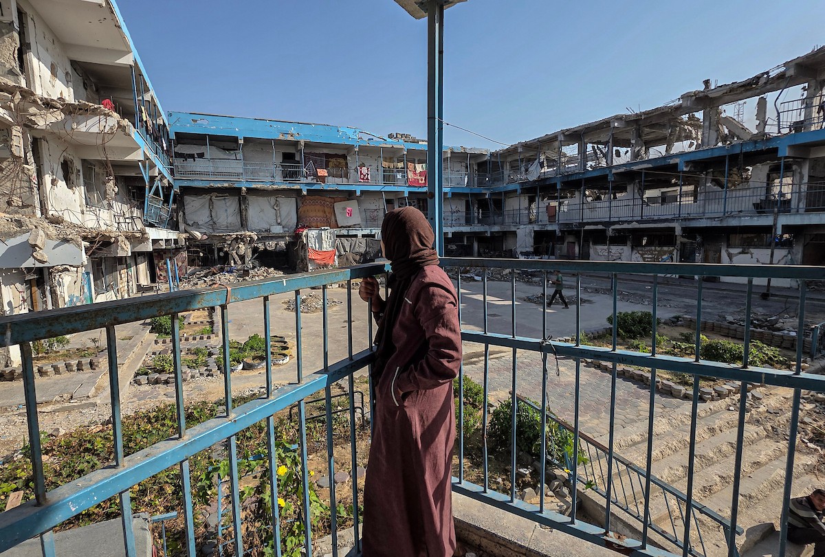 امرأة فلسطينية تأوي مع أطفالها داخل مدرسة مدمرة قرب خط التماس الخط الأصفر شرق خان يونس.jpg