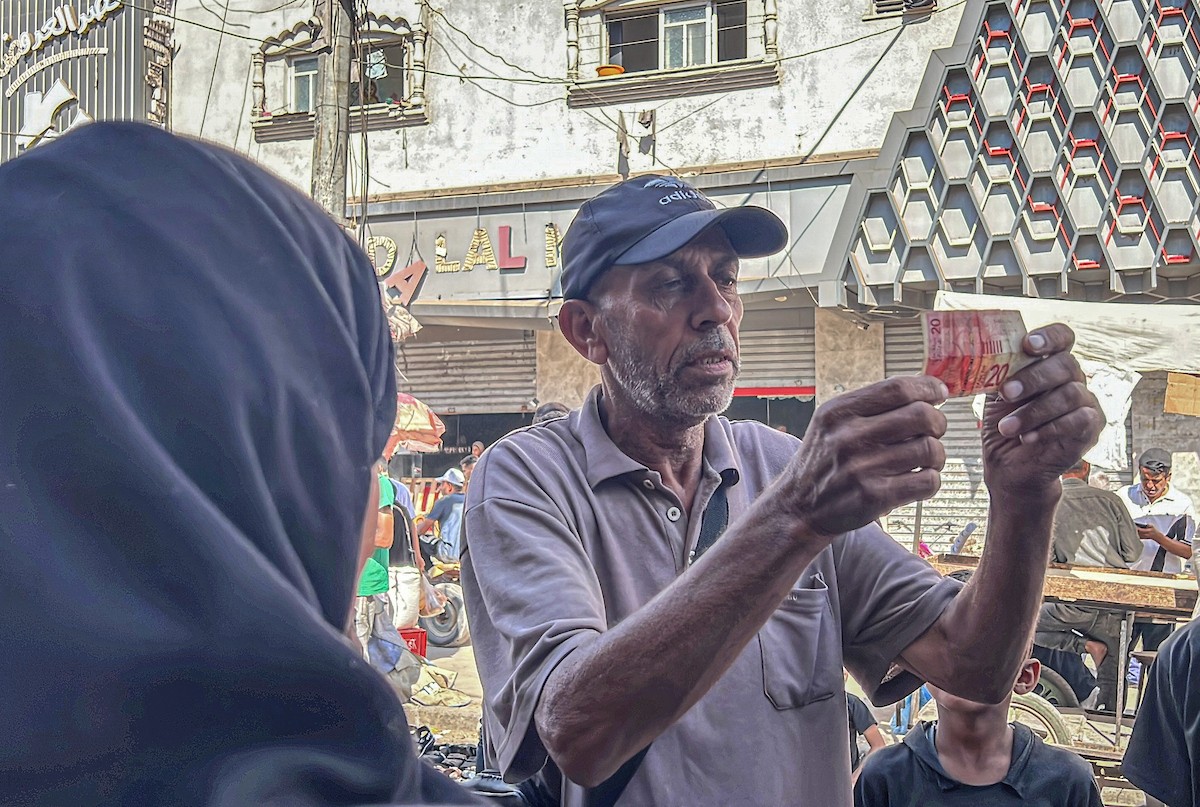 الفلسطينية منال السعيداني تُصلح أوراقًا نقدية قديمة ومهترئة في ظل نفاد العملة الصعبة في قطاع غزة (14).jpg