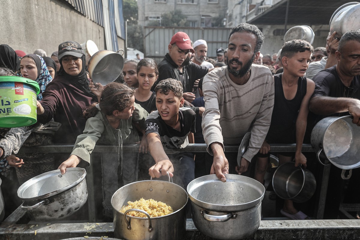 طوابير طويلة للحصول على وجبات ساخنة توزعها جمعيات خيرية في مخيم النصيرات