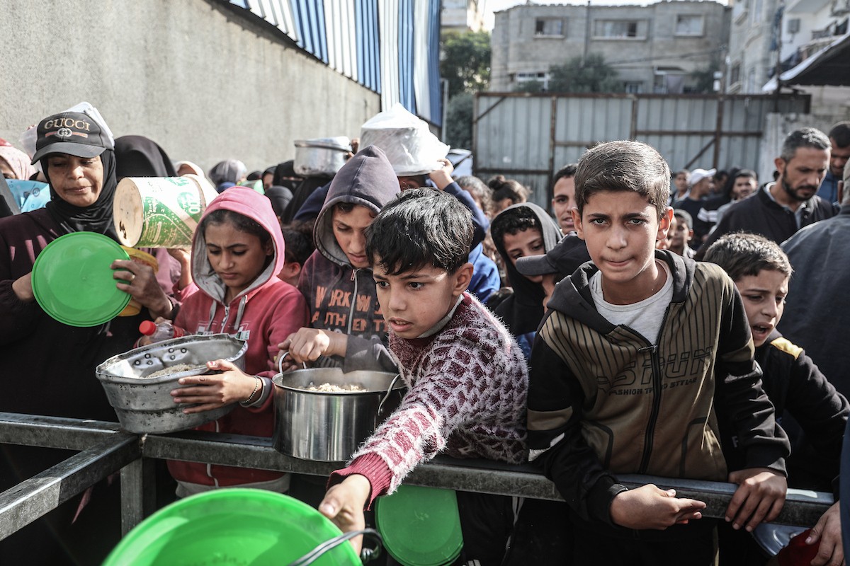 فلسطينيون في مخيم النصيرات وسط قطاع غزة يتلقون وجبات ساخنة من جمعية خيرية للنازحين