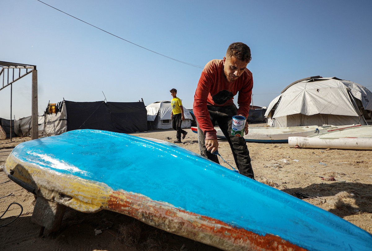 حرفيون يُصلحون قوارب الصيد في ورشة بميناء غزة البحري.jpg