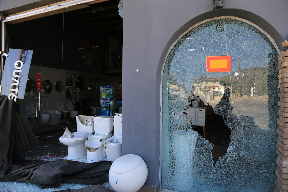 يتفقد الفلسطيني محمد مرقة متجره المتضرر بعد أن هاجمته مجموعة من المستوط (3).JPG