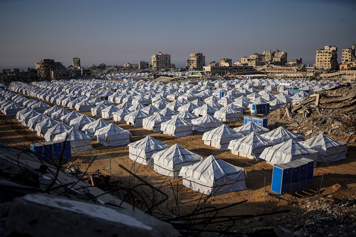 نازحون فلسطينيون يسيرون وسط ملاجئ مؤقتة شمال مدينة غزة
