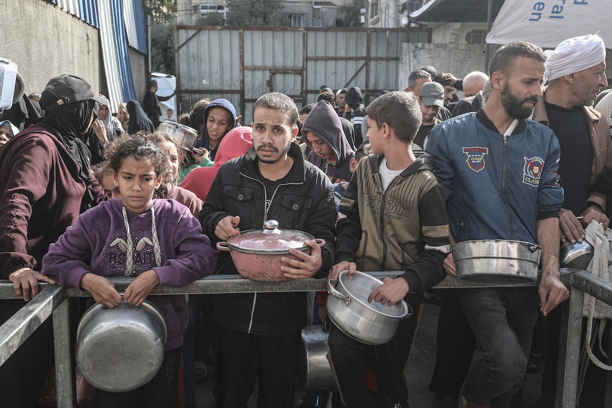 فلسطينيون في مخيم النصيرات وسط قطاع غزة يتلقون وجبات ساخنة من جمعية خيرية للنازحين