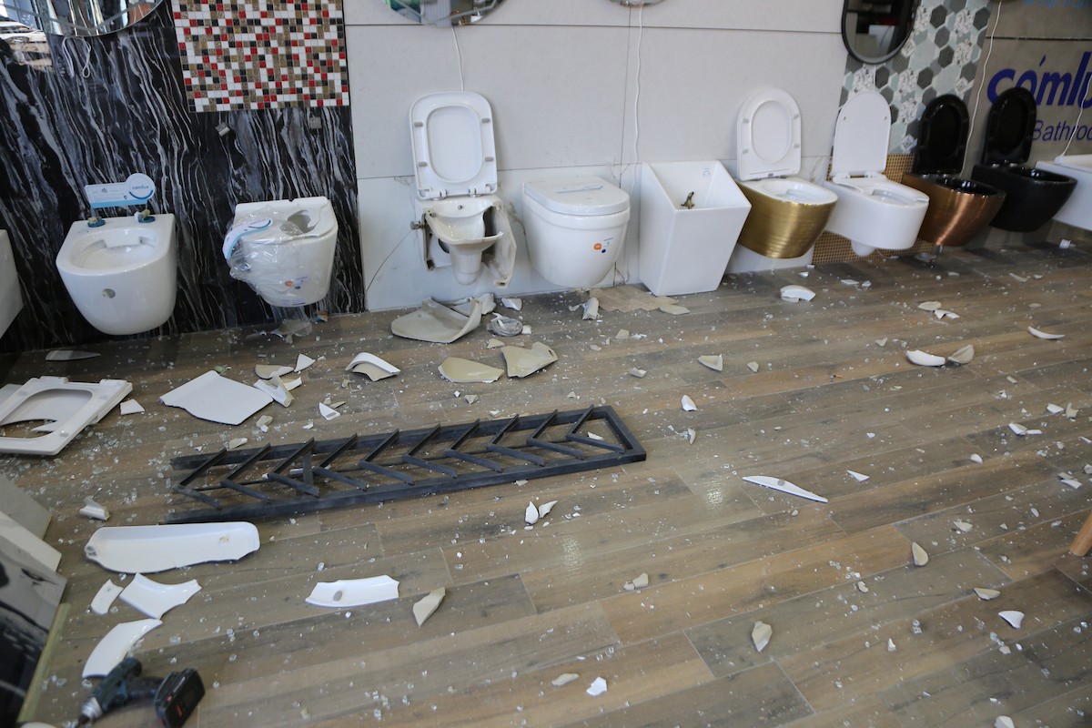 يتفقد الفلسطيني محمد مرقة متجره المتضرر بعد أن هاجمته مجموعة من المستوطني.JPG