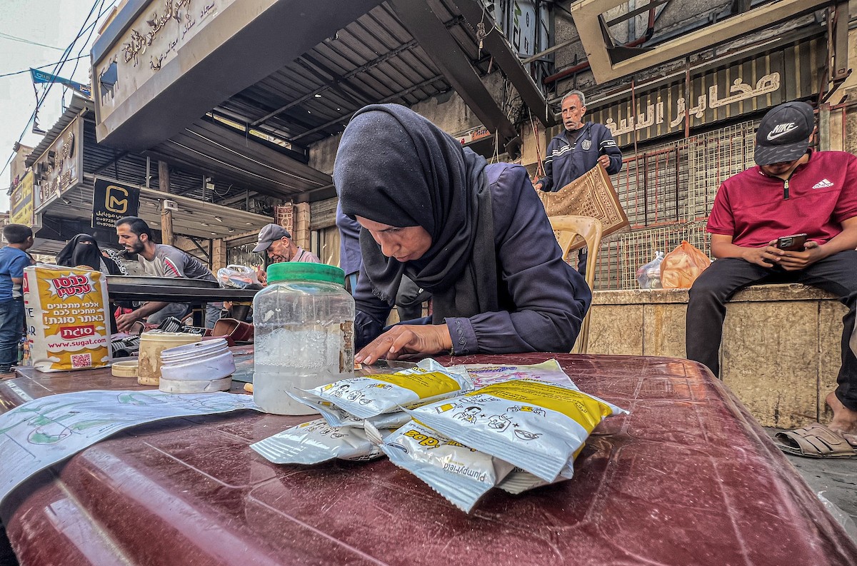 الفلسطينية منال السعيداني تُصلح أوراقًا نقدية قديمة ومهترئة في ظل نفاد العملة الصعبة في قطاع غزة (5).jpg