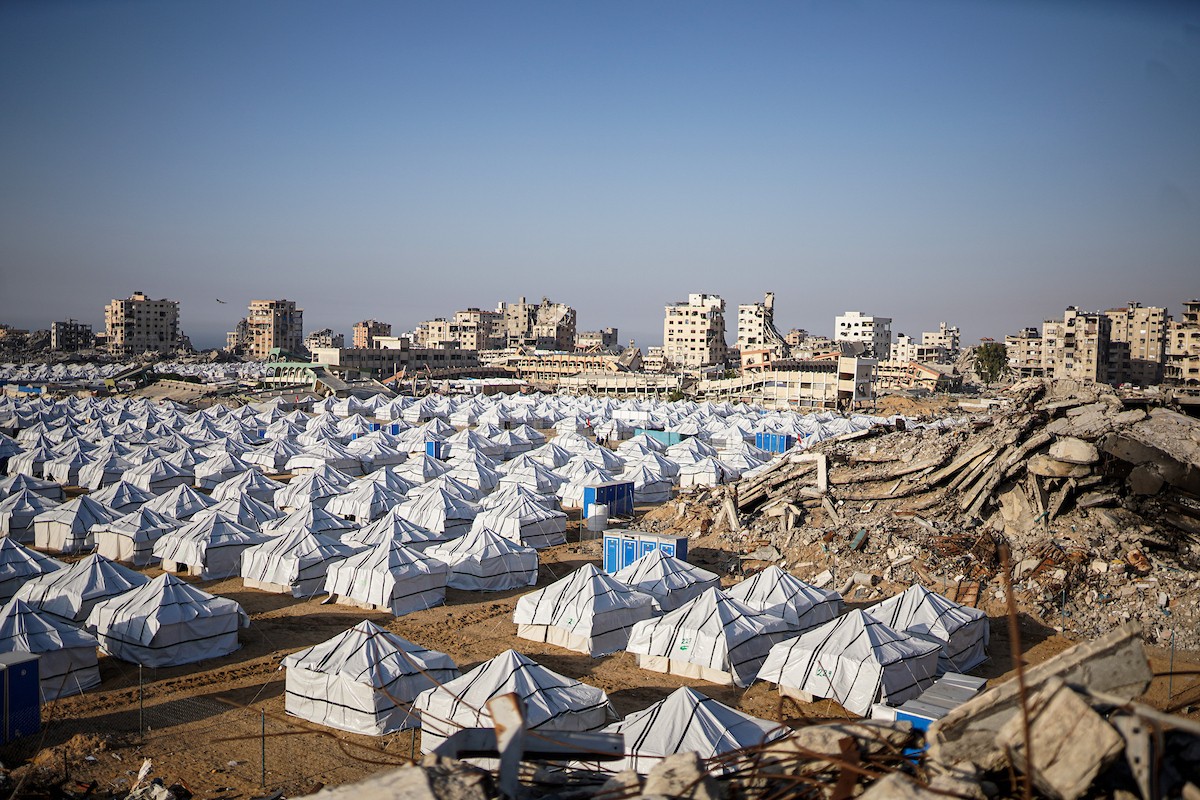 نازحون فلسطينيون يسيرون وسط ملاجئ مؤقتة شمال مدينة غزة
