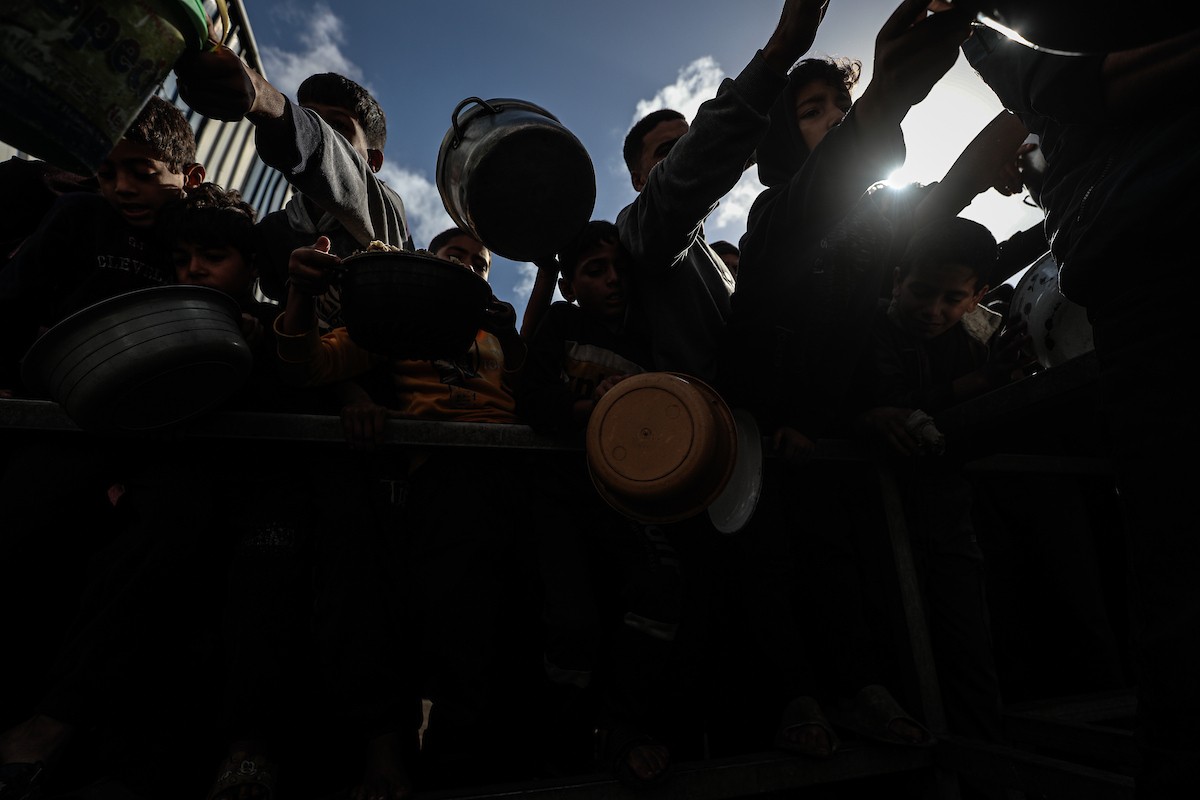 فلسطينيون في مخيم النصيرات وسط قطاع غزة يتلقون وجبات ساخنة من جمعية خيرية للنازحين