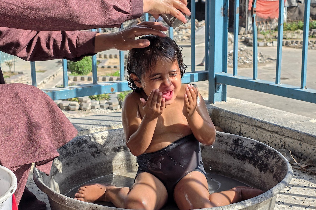 امرأة فلسطينية تأوي مع أطفالها داخل مدرسة مدمرة قرب خط التماس الخط الأصفر شرق خان يونس (7).jpg