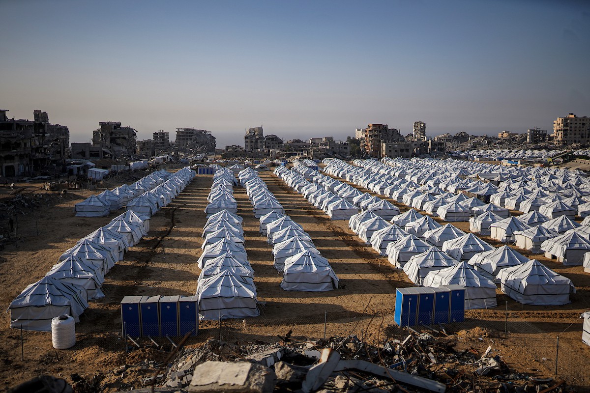 نازحون فلسطينيون يسيرون وسط ملاجئ مؤقتة شمال مدينة غزة