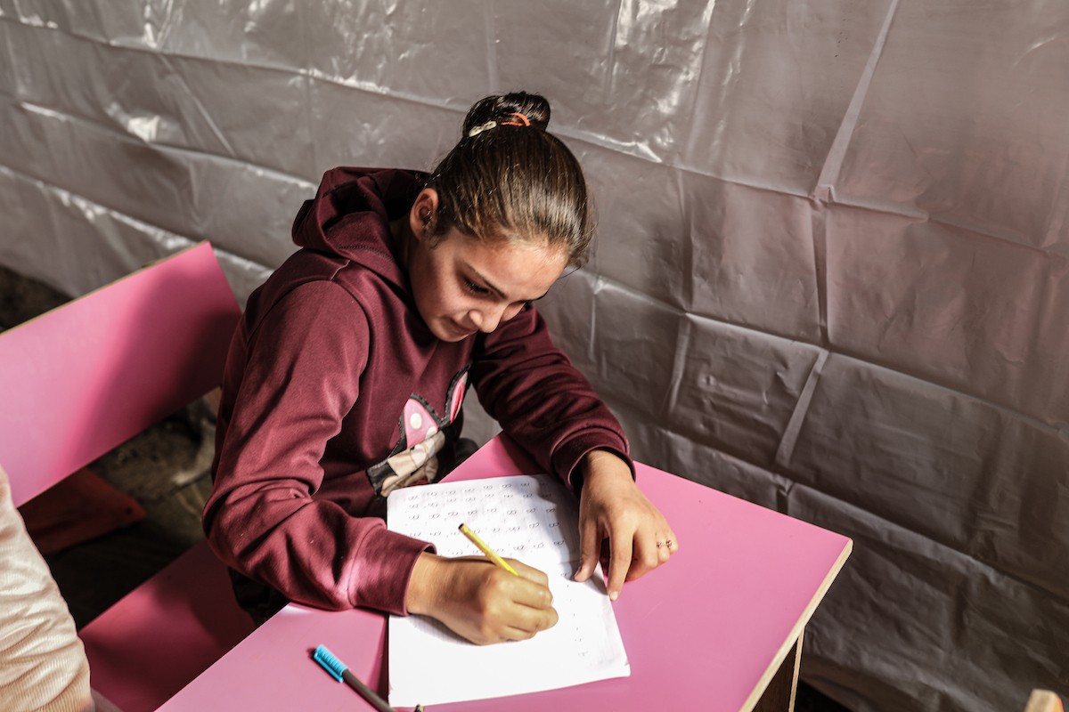 أطفال فلسطينيون نازحون يحضرون درسًا داخل خيمة تُستخدم كفصل دراسي مؤقت في ملجأ بدير البلح (15).jpg