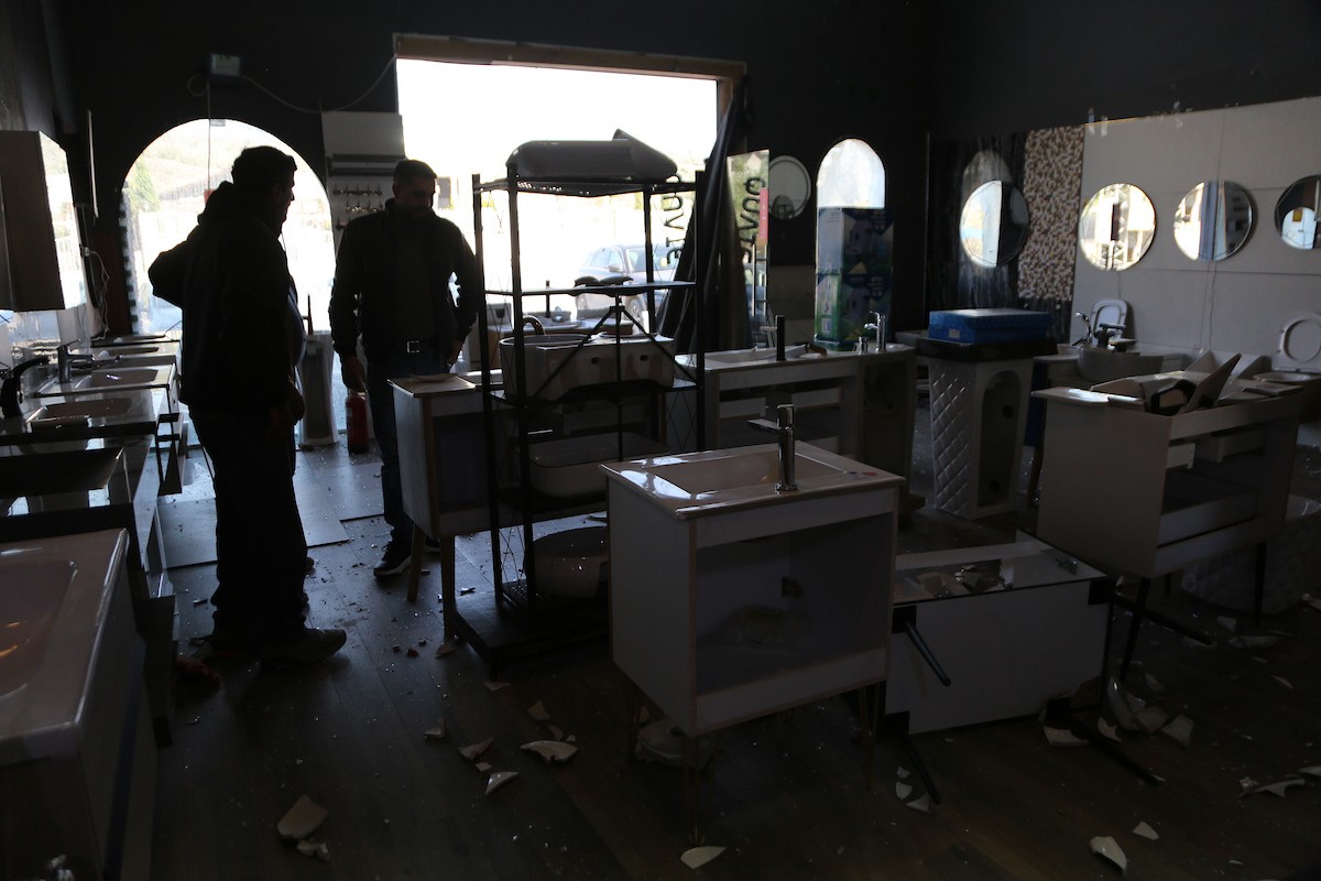 يتفقد الفلسطيني محمد مرقة متجره المتضرر بعد أن هاجمته مجموعة من المستوط (5).JPG