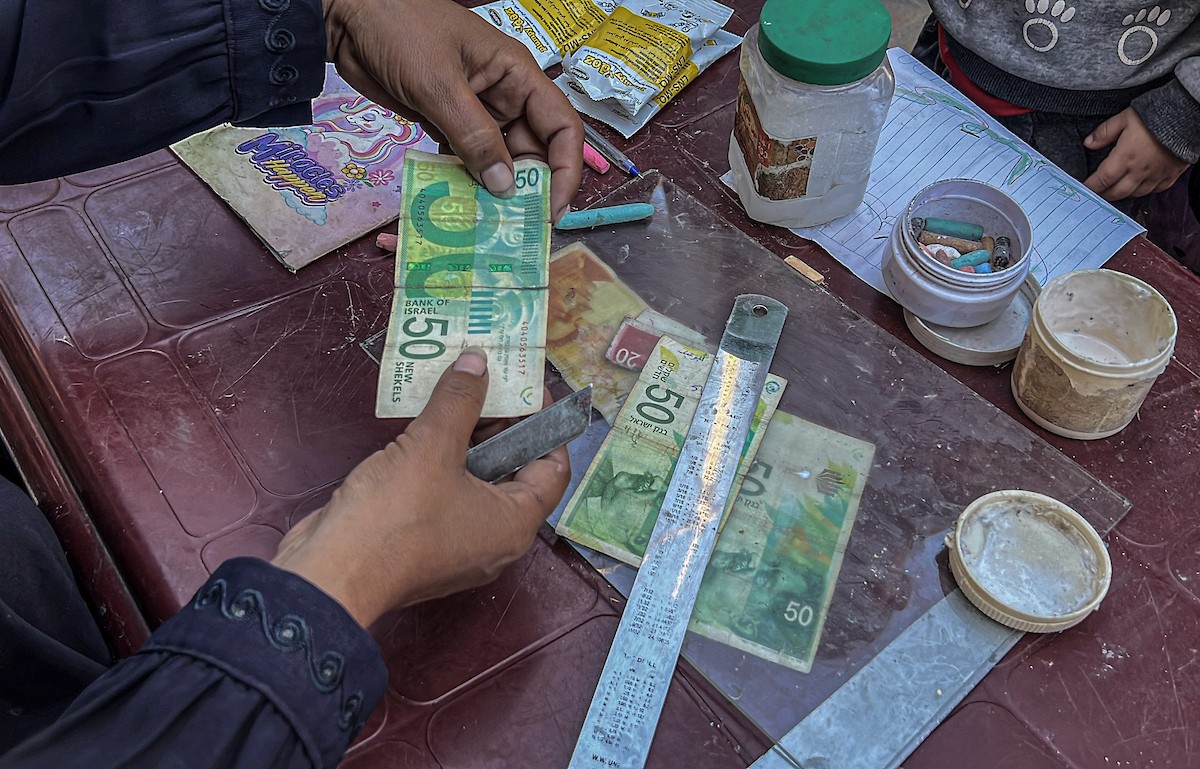 الفلسطينية منال السعيداني تُصلح أوراقًا نقدية قديمة ومهترئة في ظل نفاد العملة الصعبة في قطاع غزة (18).jpg