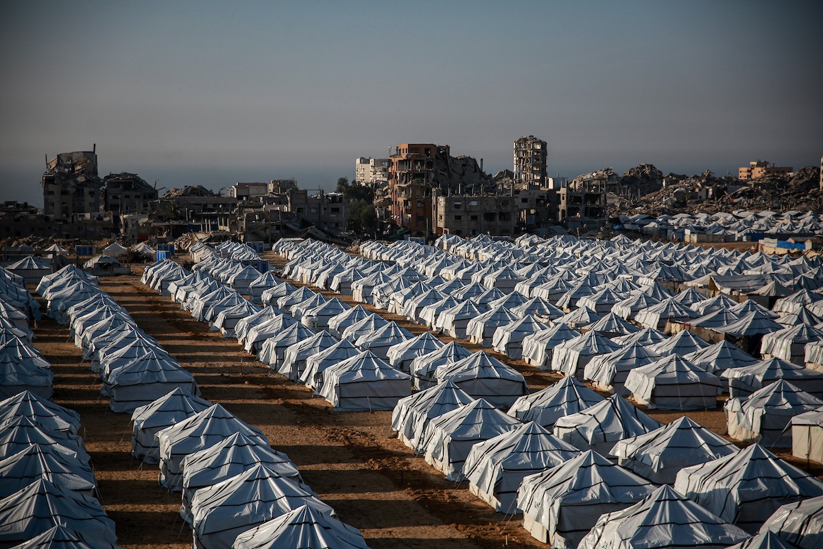 نازحون فلسطينيون يسيرون وسط ملاجئ مؤقتة شمال مدينة غزة