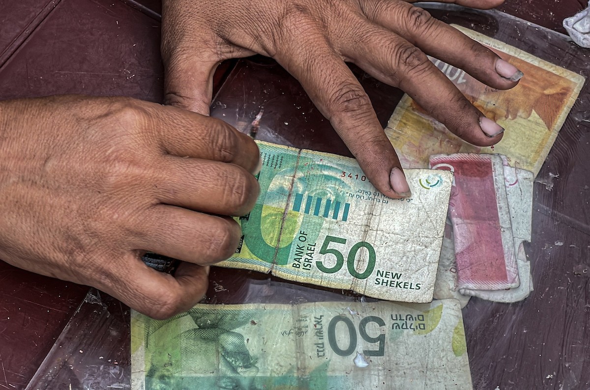 الفلسطينية منال السعيداني تُصلح أوراقًا نقدية قديمة ومهترئة في ظل نفاد العملة الصعبة في قطاع غزة (16).jpg