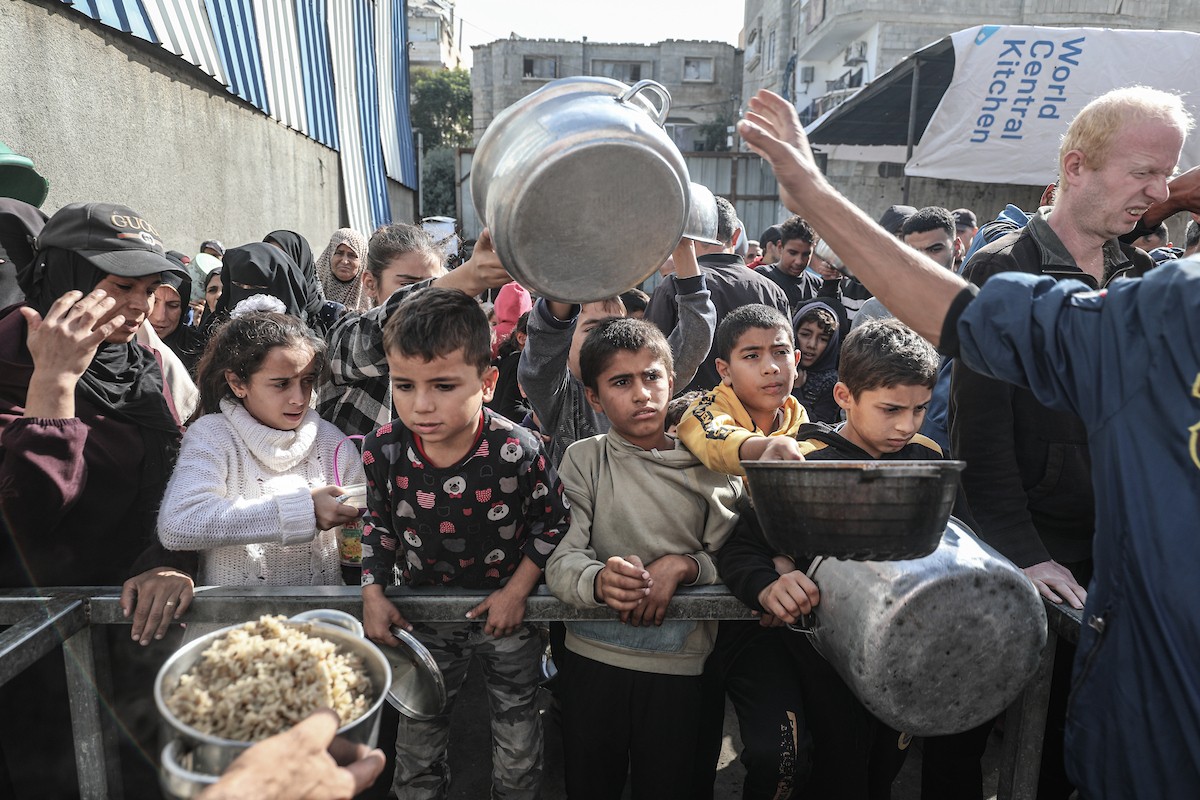 فلسطينيون في مخيم النصيرات وسط قطاع غزة يتلقون وجبات ساخنة من جمعية خيرية للنازحين