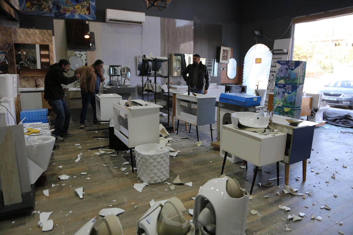 يتفقد الفلسطيني محمد مرقة متجره المتضرر بعد أن هاجمته مجموعة من المستوط (8).JPG