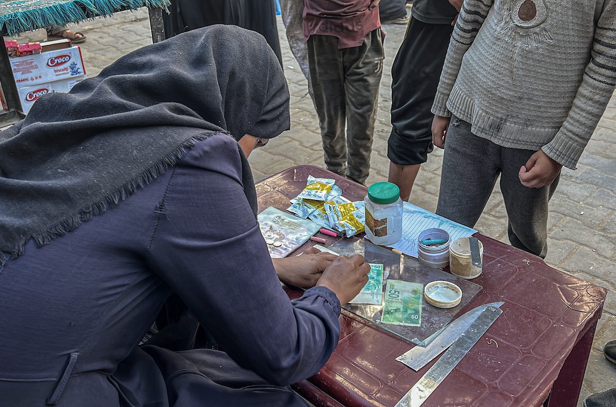 الفلسطينية منال السعيداني تُصلح أوراقًا نقدية قديمة ومهترئة في ظل نفاد العملة الصعبة في قطاع غزة (15).jpg