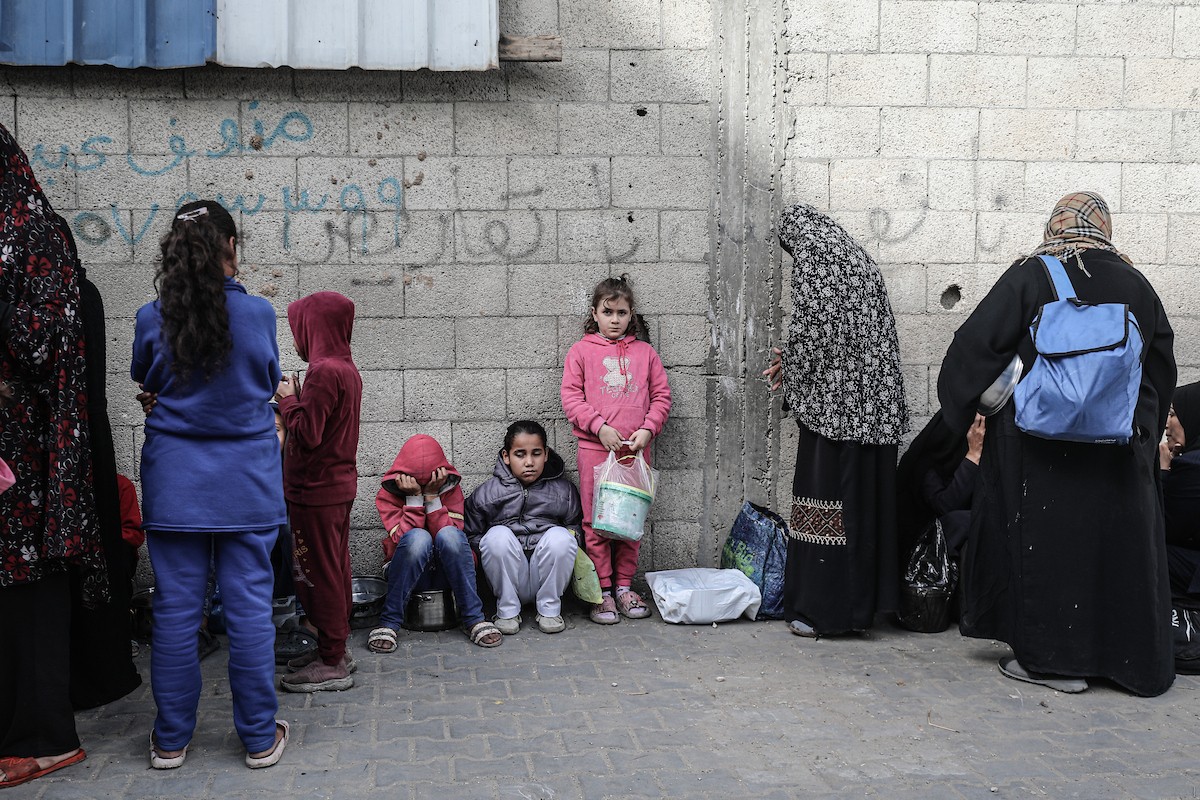 فلسطينيون في مخيم النصيرات وسط قطاع غزة يتلقون وجبات ساخنة من جمعية خيرية للنازحين