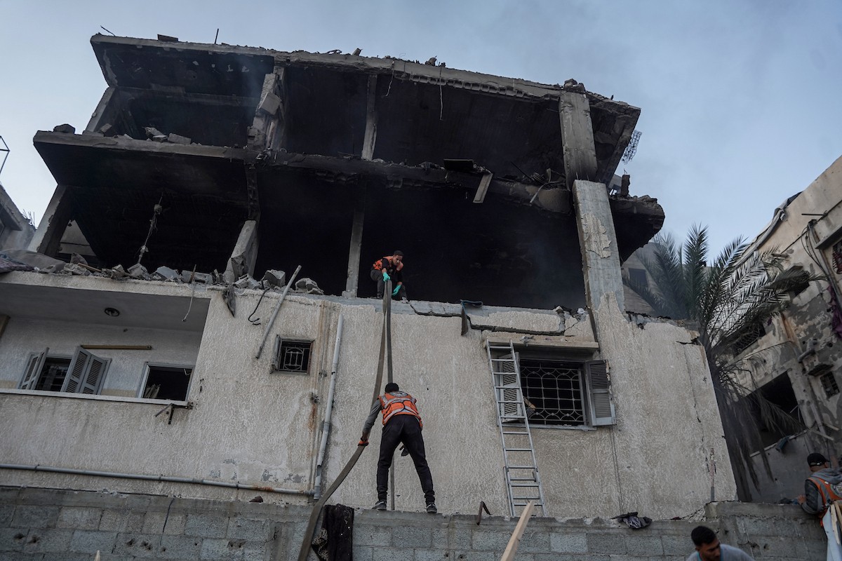 أفراد الدفاع المدني يبحثون في منزل محترق استهدفه غارات جوية إسرائيلية في مدينة غزة، في 22 نوفمبرتشرين الثاني 2025 (3).jpg
