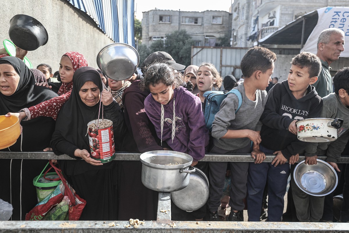 فلسطينيون في مخيم النصيرات وسط قطاع غزة يتلقون وجبات ساخنة من جمعية خيرية للنازحين