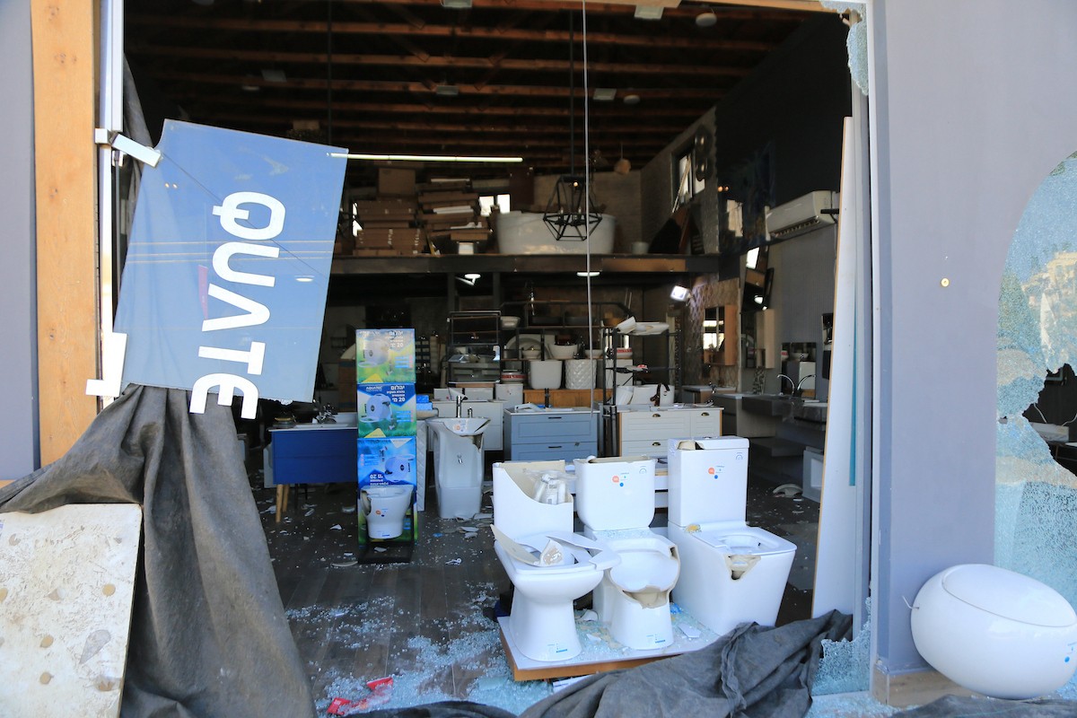 يتفقد الفلسطيني محمد مرقة متجره المتضرر بعد أن هاجمته مجموعة من المستوط (2).JPG