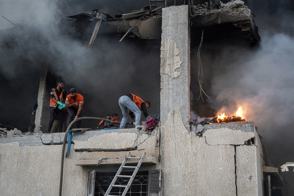 أفراد الدفاع المدني يبحثون في منزل محترق استهدفه غارات جوية إسرائيلية في مدينة غزة، في 22 نوفمبرتشرين الثاني 2025 (4).jpg