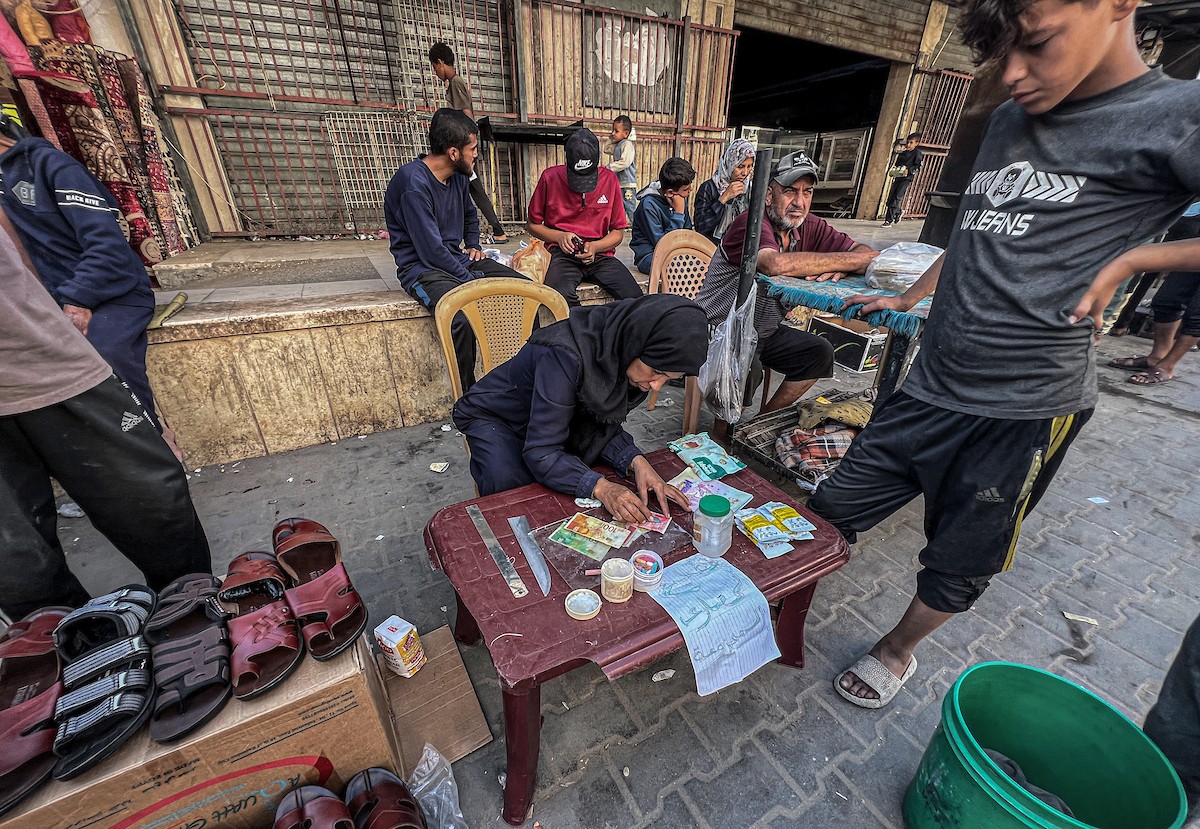 الفلسطينية منال السعيداني تُصلح أوراقًا نقدية قديمة ومهترئة في ظل نفاد العملة الصعبة في قطاع غزة (10).jpg