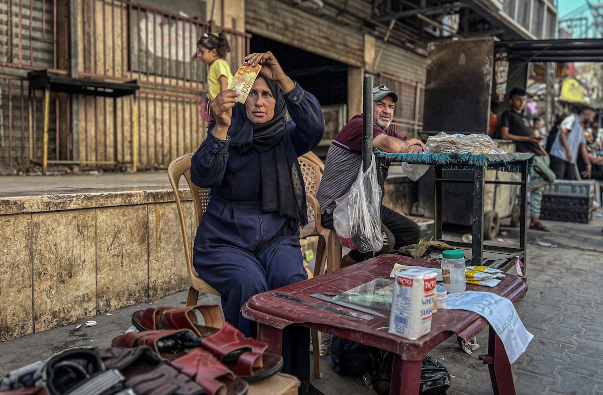 الفلسطينية منال السعيداني تُصلح أوراقًا نقدية قديمة ومهترئة في ظل نفاد العملة الصعبة في قطاع غزة (8).jpg