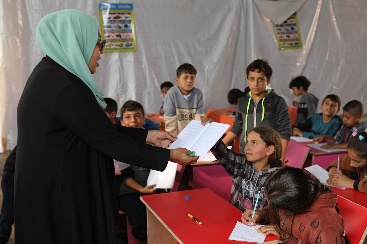 أطفال فلسطينيون نازحون يحضرون درسًا داخل خيمة تُستخدم كفصل دراسي مؤقت في ملجأ بدير البلح (14).jpg