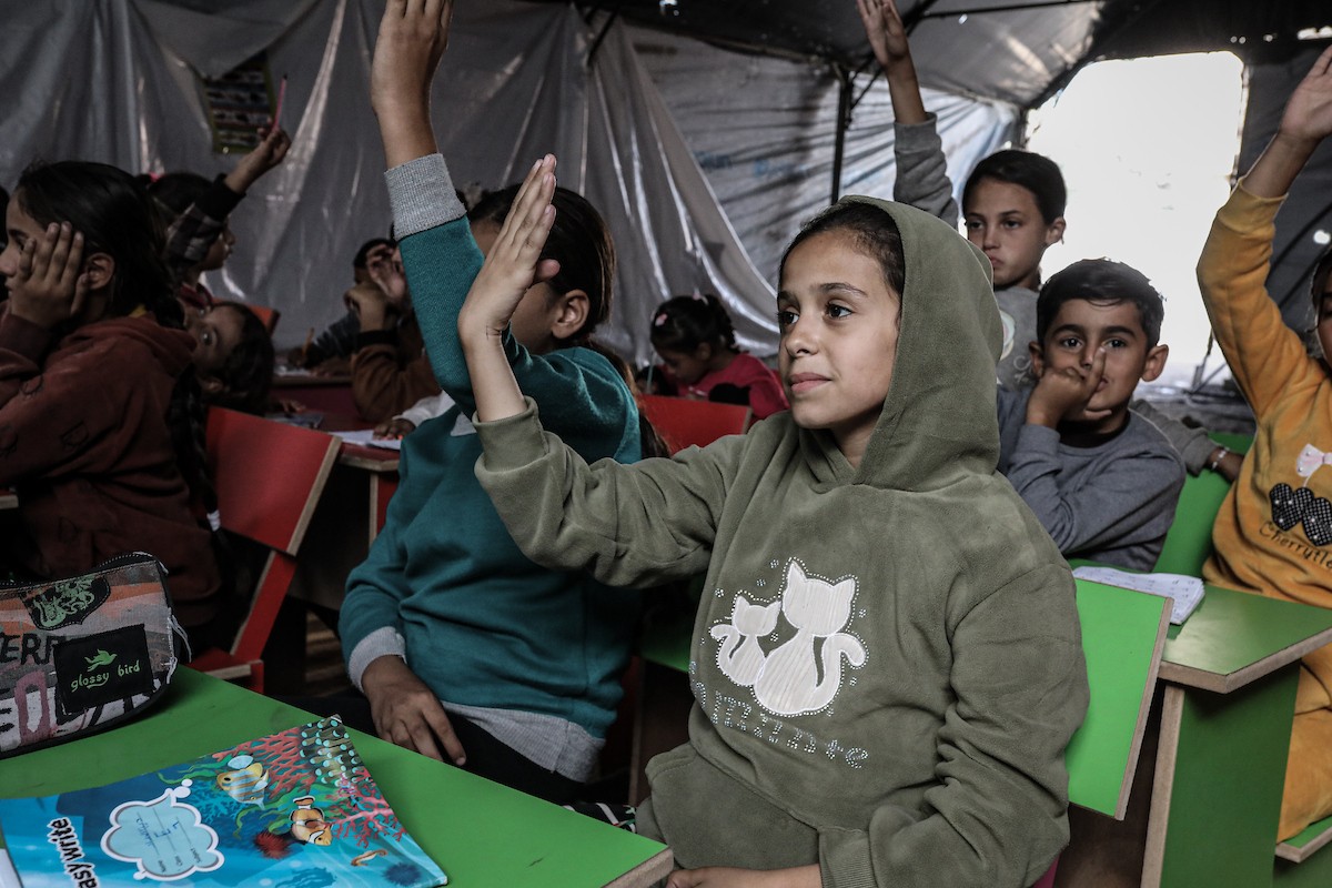 أطفال فلسطينيون نازحون يحضرون درسًا داخل خيمة تُستخدم كفصل دراسي مؤقت في ملجأ بدير البلح (5).jpg