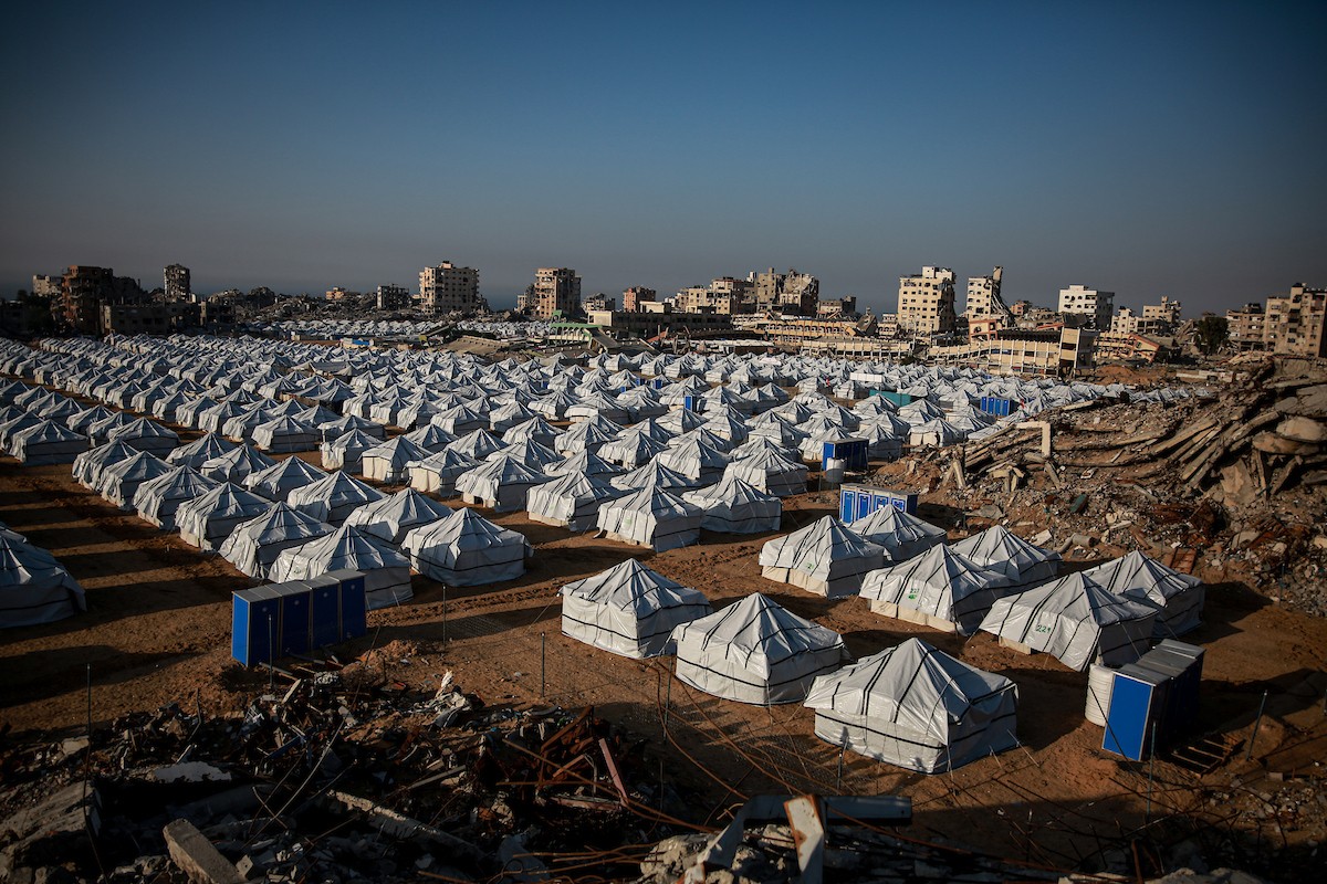 نازحون فلسطينيون يسيرون وسط ملاجئ مؤقتة شمال مدينة غزة