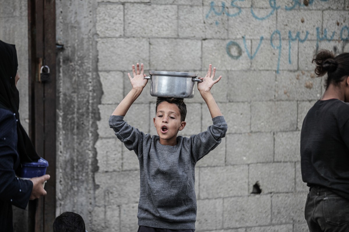 فلسطينيون في مخيم النصيرات وسط قطاع غزة يتلقون وجبات ساخنة من جمعية خيرية للنازحين