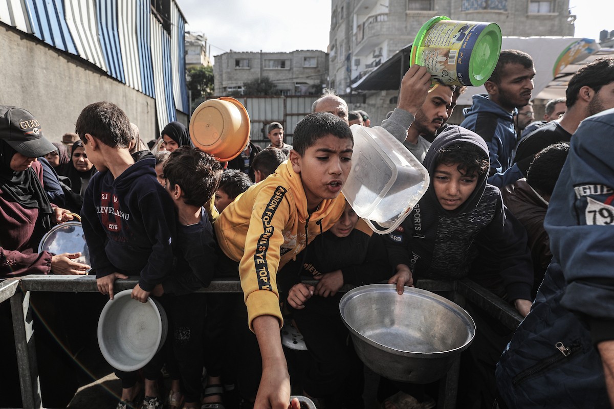 فلسطينيون في مخيم النصيرات وسط قطاع غزة يتلقون وجبات ساخنة من جمعية خيرية للنازحين