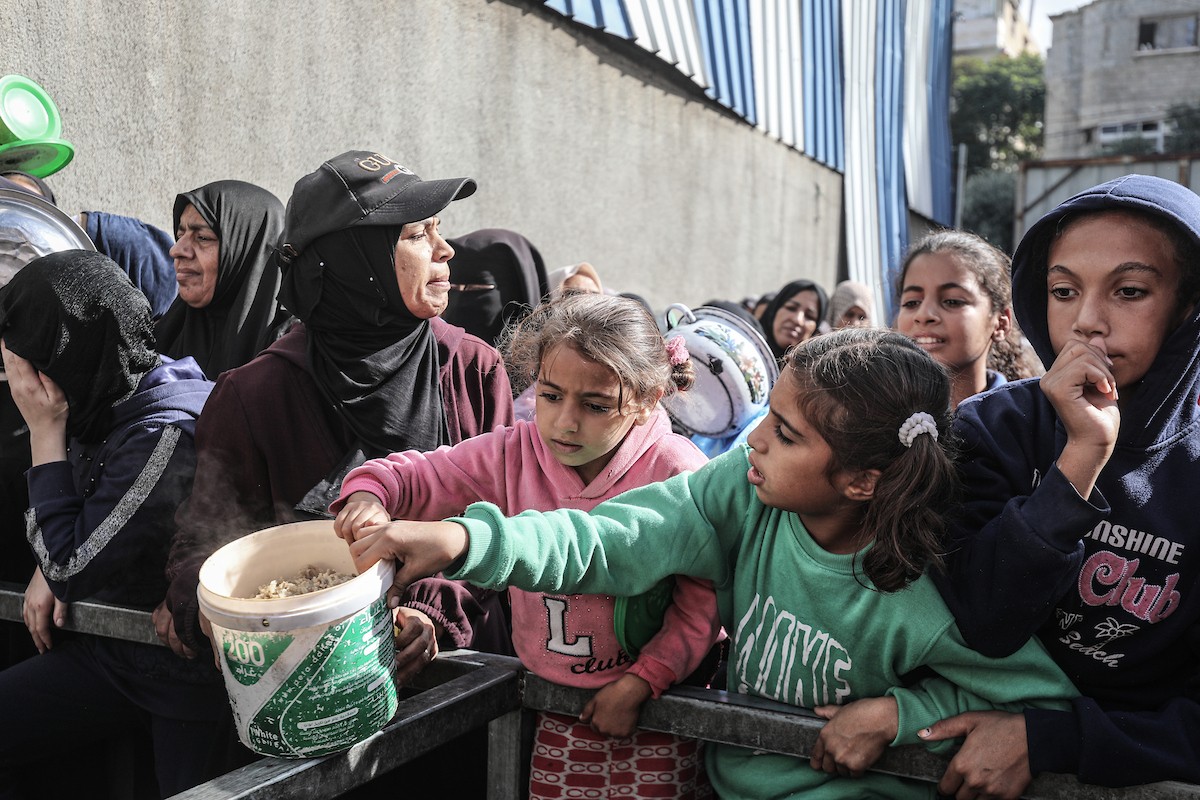 فلسطينيون في مخيم النصيرات وسط قطاع غزة يتلقون وجبات ساخنة من جمعية خيرية للنازحين