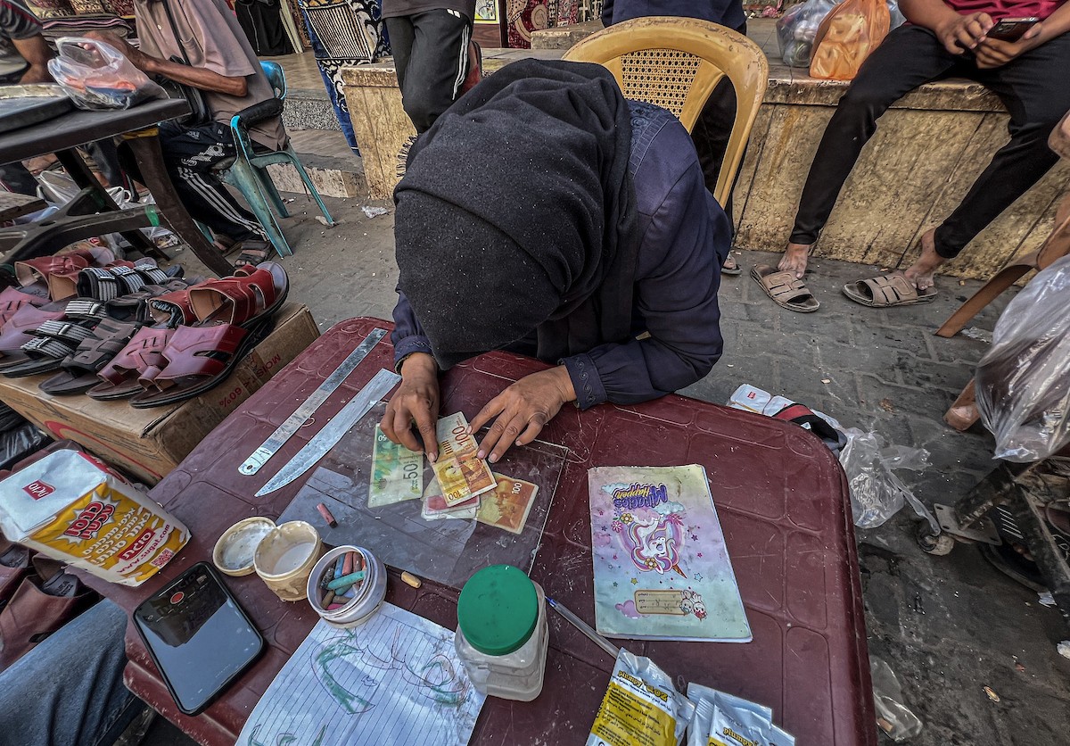 الفلسطينية منال السعيداني تُصلح أوراقًا نقدية قديمة ومهترئة في ظل نفاد العملة الصعبة في قطاع غزة (9).jpg