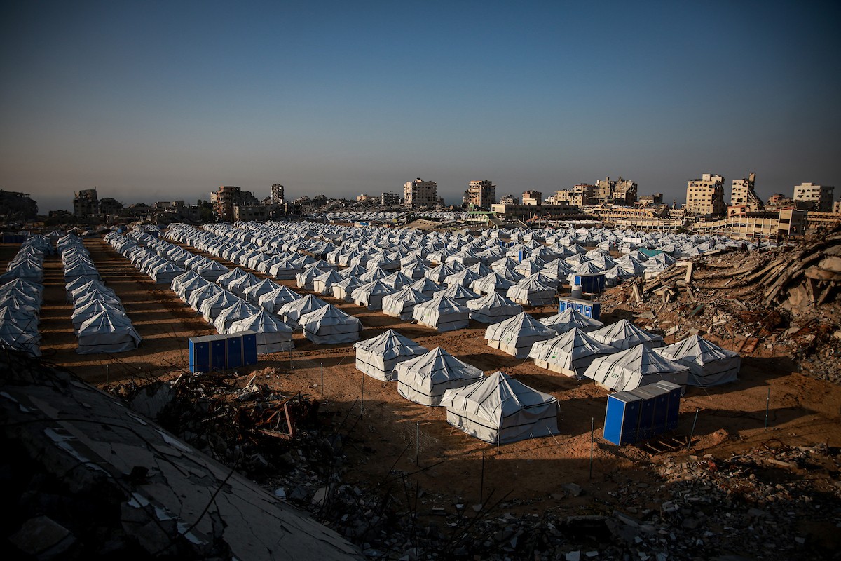 نازحون فلسطينيون يسيرون وسط ملاجئ مؤقتة شمال مدينة غزة