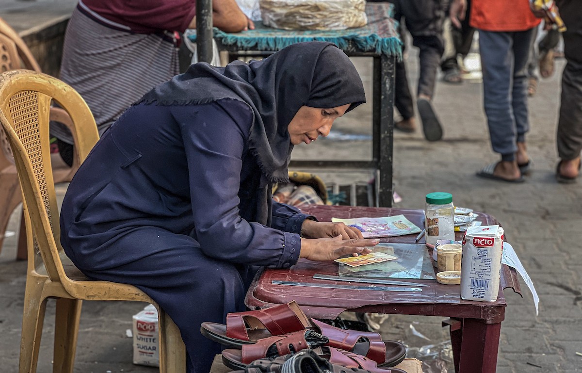الفلسطينية منال السعيداني تُصلح أوراقًا نقدية قديمة ومهترئة في ظل نفاد العملة الصعبة في قطاع غزة (3).jpg